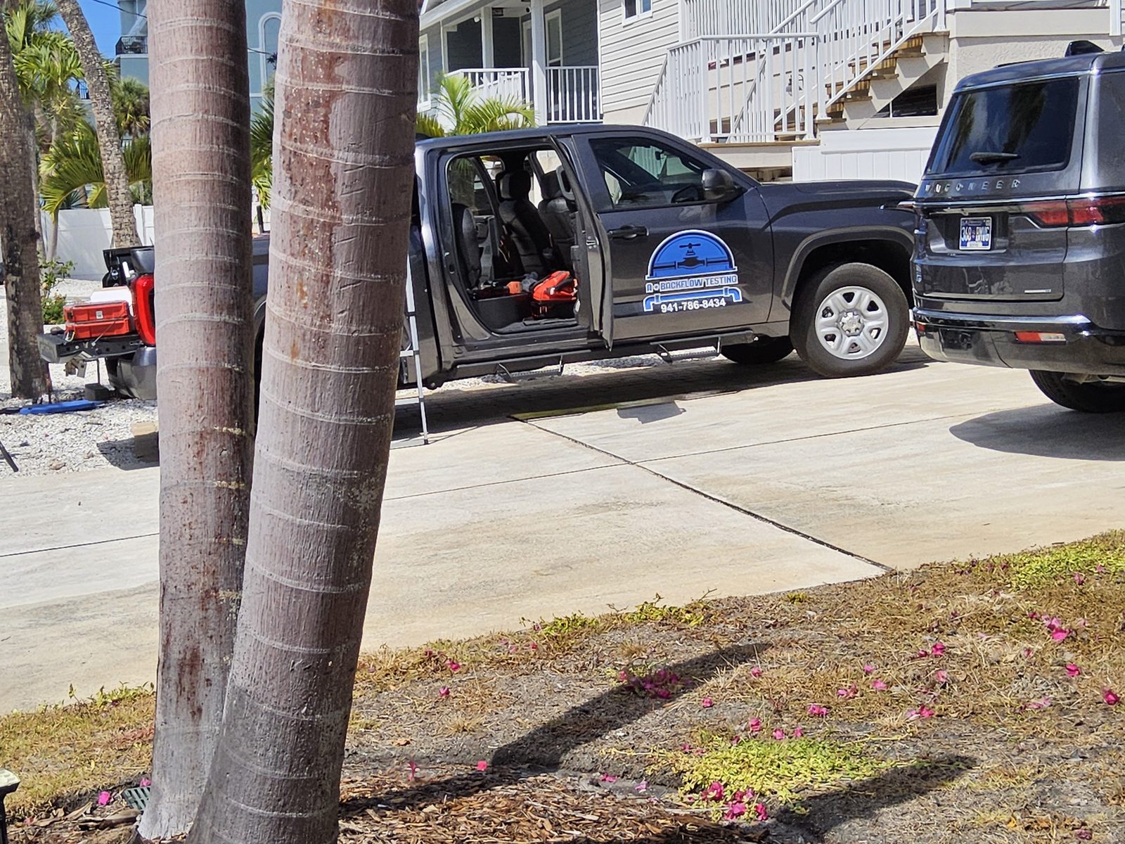 A Plus Backflow Testing service truck parked at a Charlotte County, FL customer property with backflow test equipment in the cab.