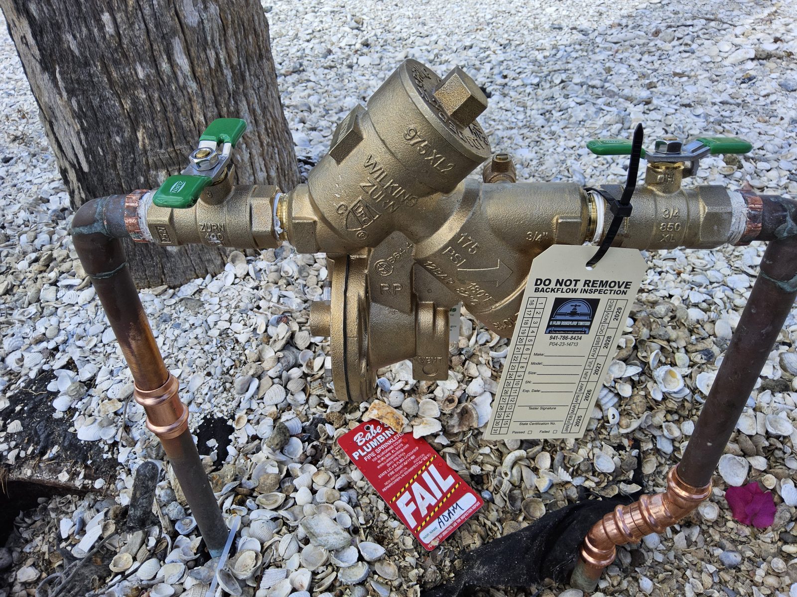 Wilkins Zurn 975XL2 RPZ with a red FAIL tag from a prior inspection, staged for diagnostic and repair by A Plus Backflow Testing in Charlotte County, FL.