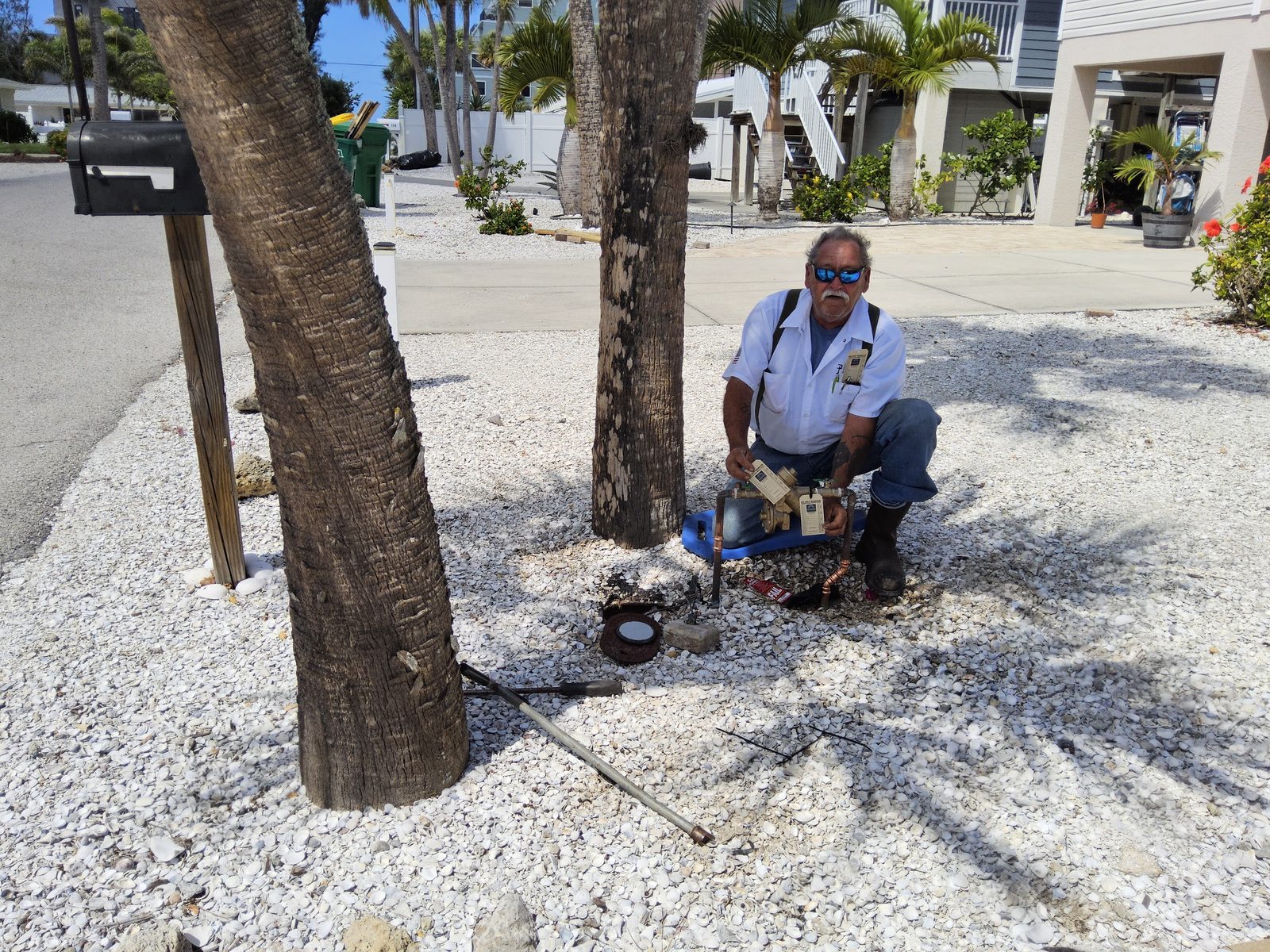Scott Eason, owner of A Plus Backflow Testing and Florida BAT #PR14723, kneeling beside a residential backflow preventer during an on-site test.